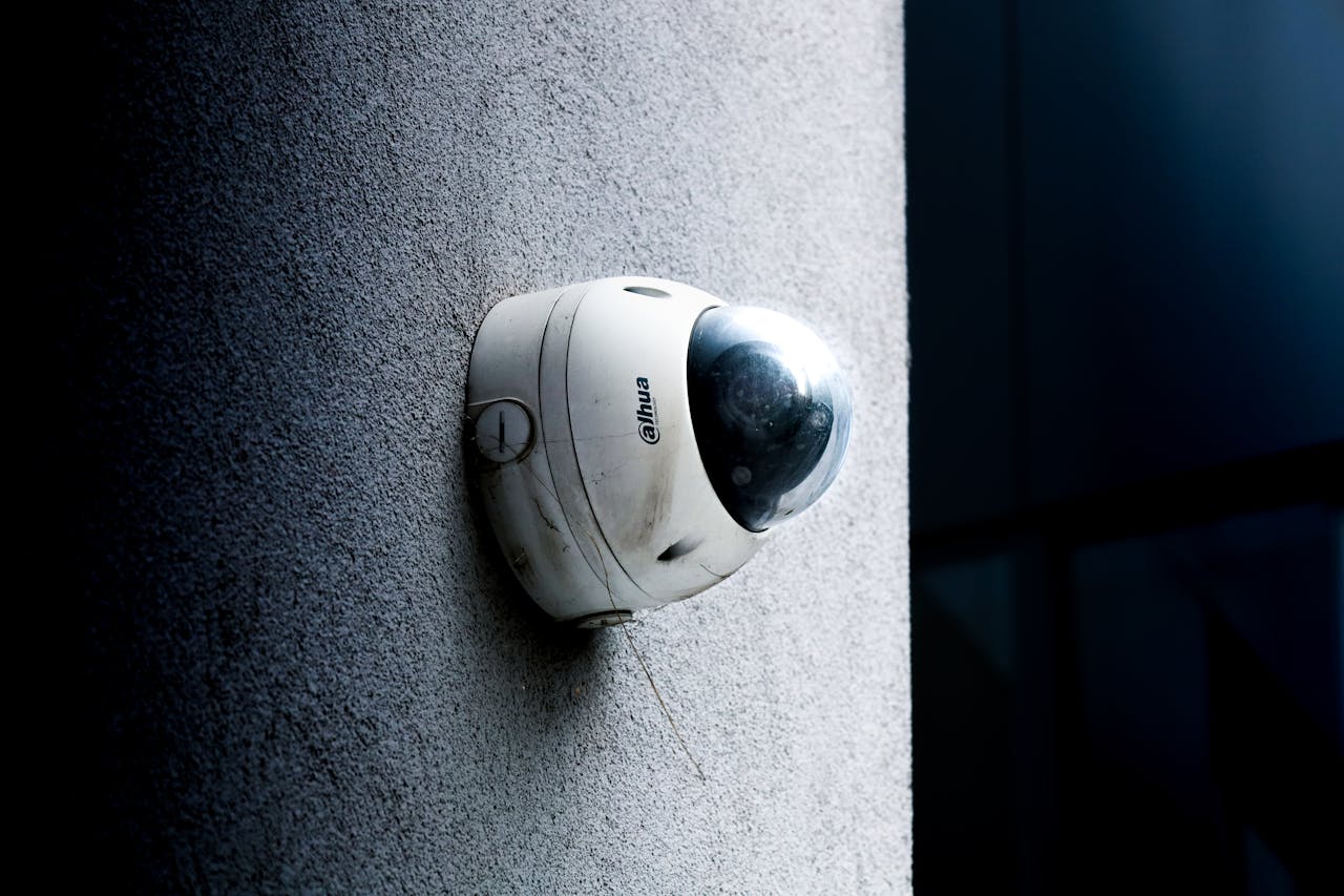 Services Close-up view of a dome security camera mounted on a concrete wall for surveillance.